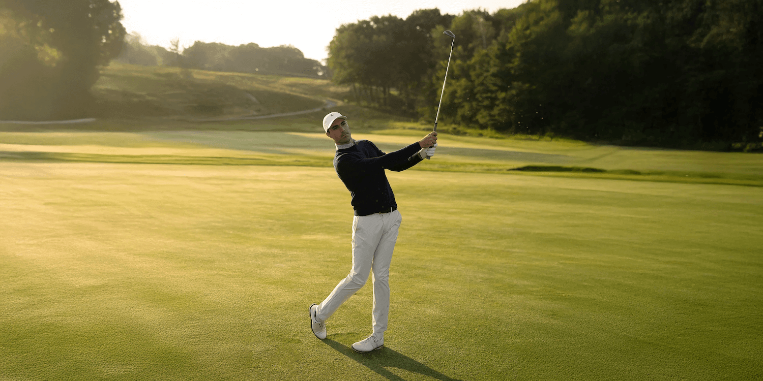 golfer holding finish of golf swing wearing holderness and bourne golf clothes